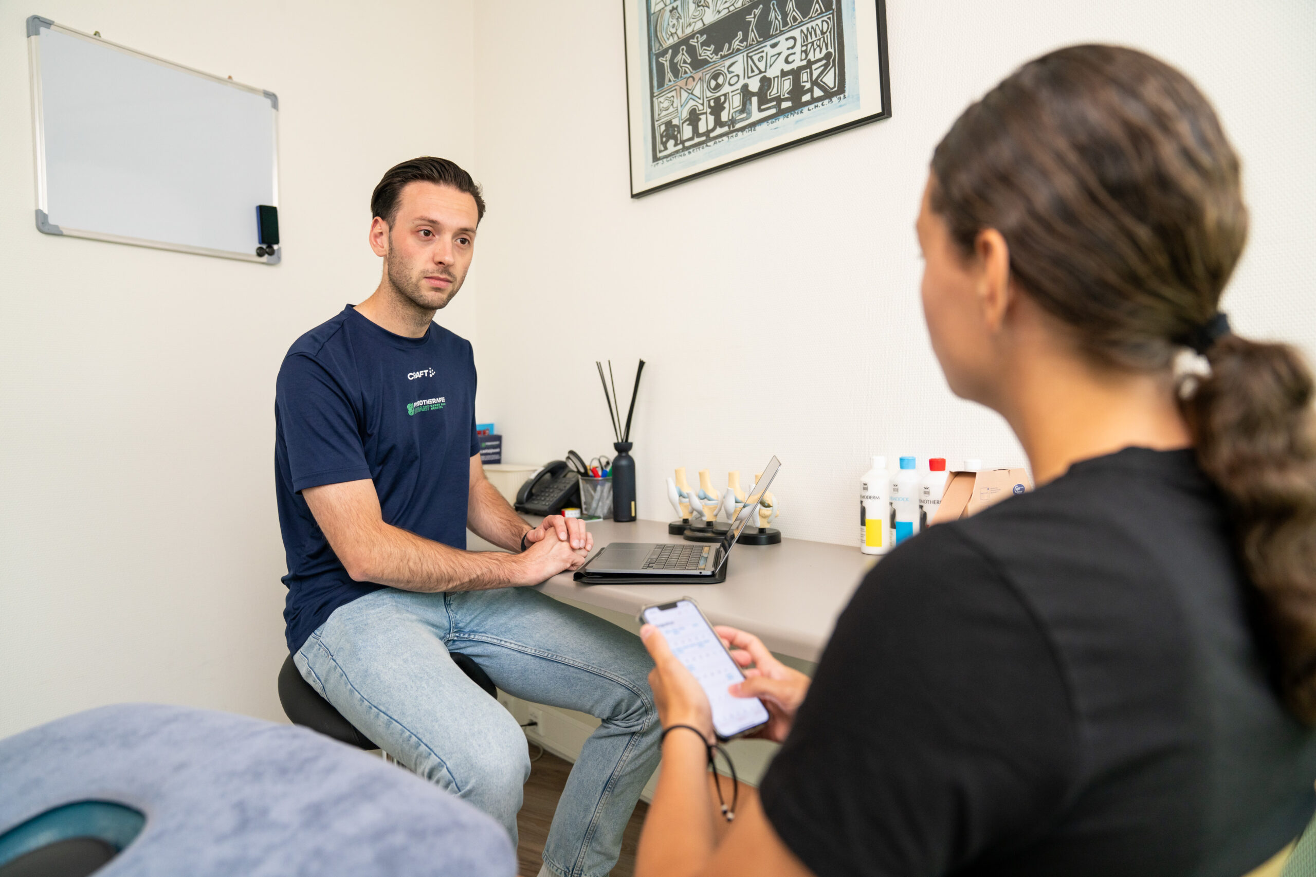 Fysiotherapeut bespreekt nekklachten met patiënt bij Fysiotherapie Dunant