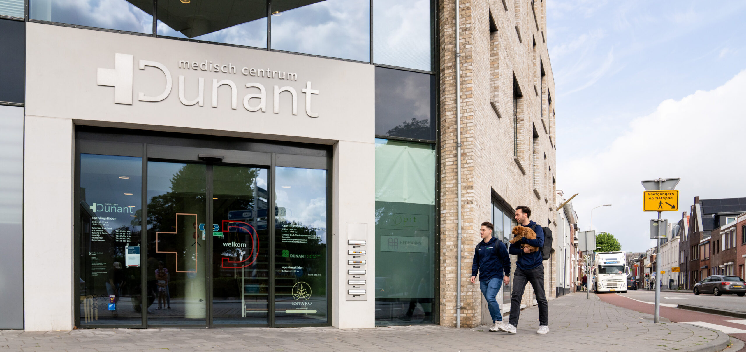 Foto van de buitenkant van Fysiotherapie Dunant, zicht op ingang en gebouw.