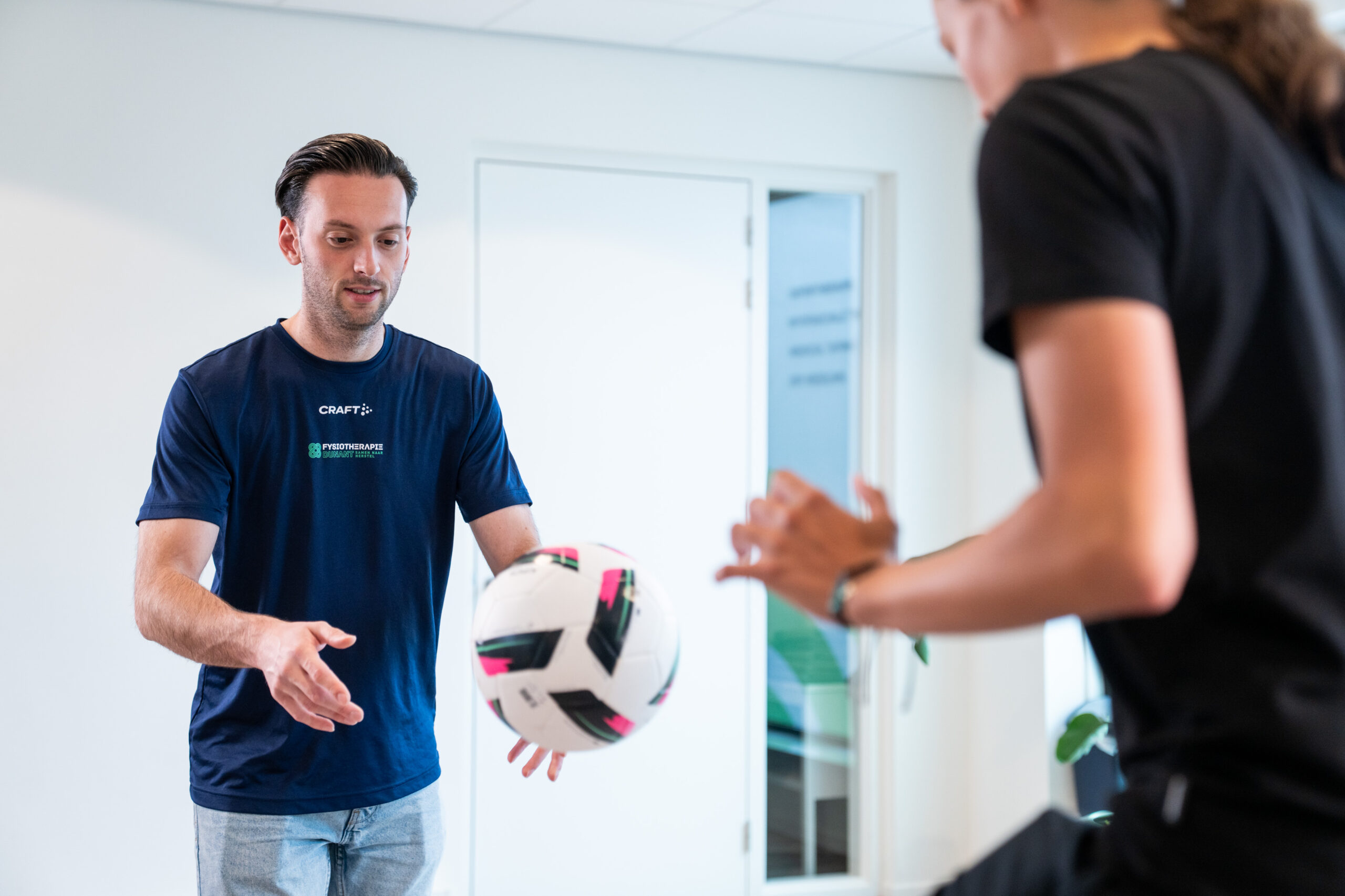 Fysiotherapeut begeleidt patiënt met sportblessure in oefenzaal - Fysiotherapie Dunant Roosendaal